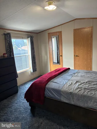a bedroom with a bed wooden floor and window