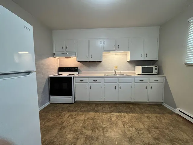 a kitchen with granite countertop a stove sink and cabinets