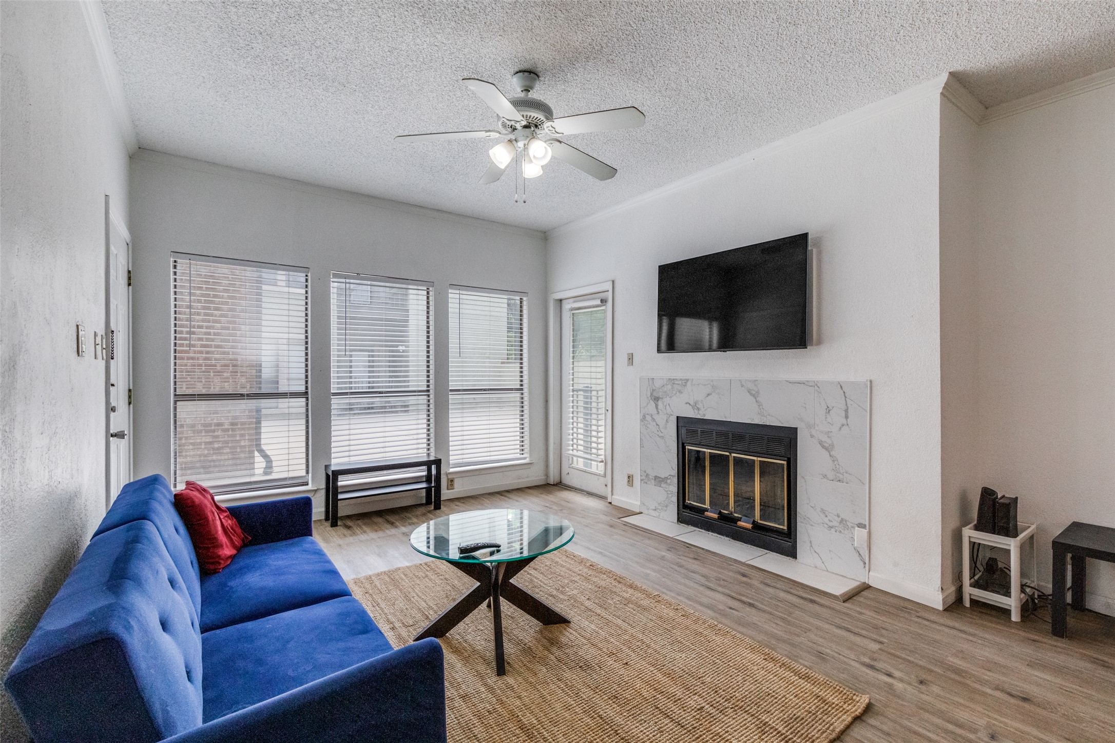 807 West 25th Street, Unit 214 Austin, TX 78705 - Photo 16 of 26 a living room with furniture a fireplace and a flat screen tv