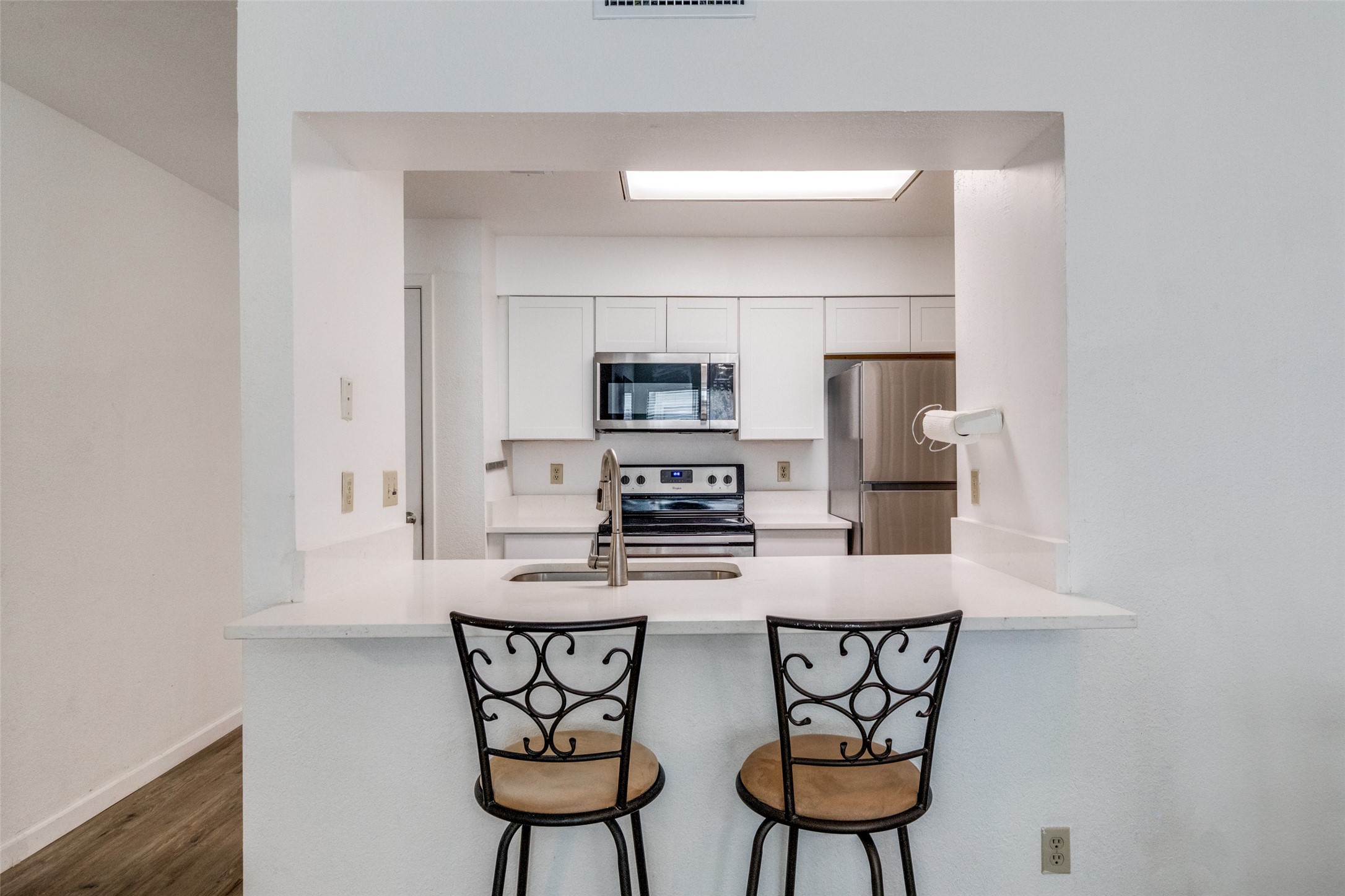 807 West 25th Street, Unit 214 Austin, TX 78705 - Photo 17 of 26 a kitchen with stainless steel appliances a stove a microwave a sink and white cabinets