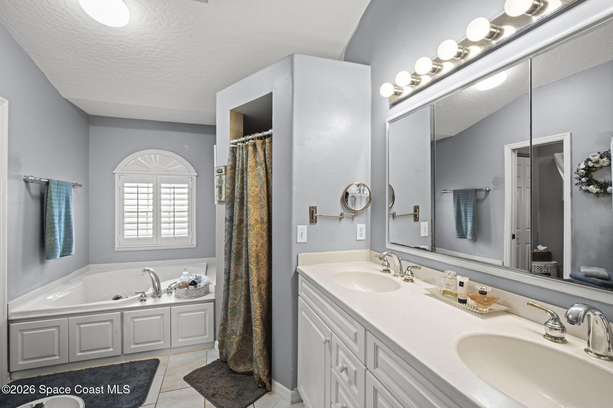 472 Arbor Street Sebastian, FL 32958 - Photo 15 of 33 a bathroom with a double vanity sink a mirror and a bathtub