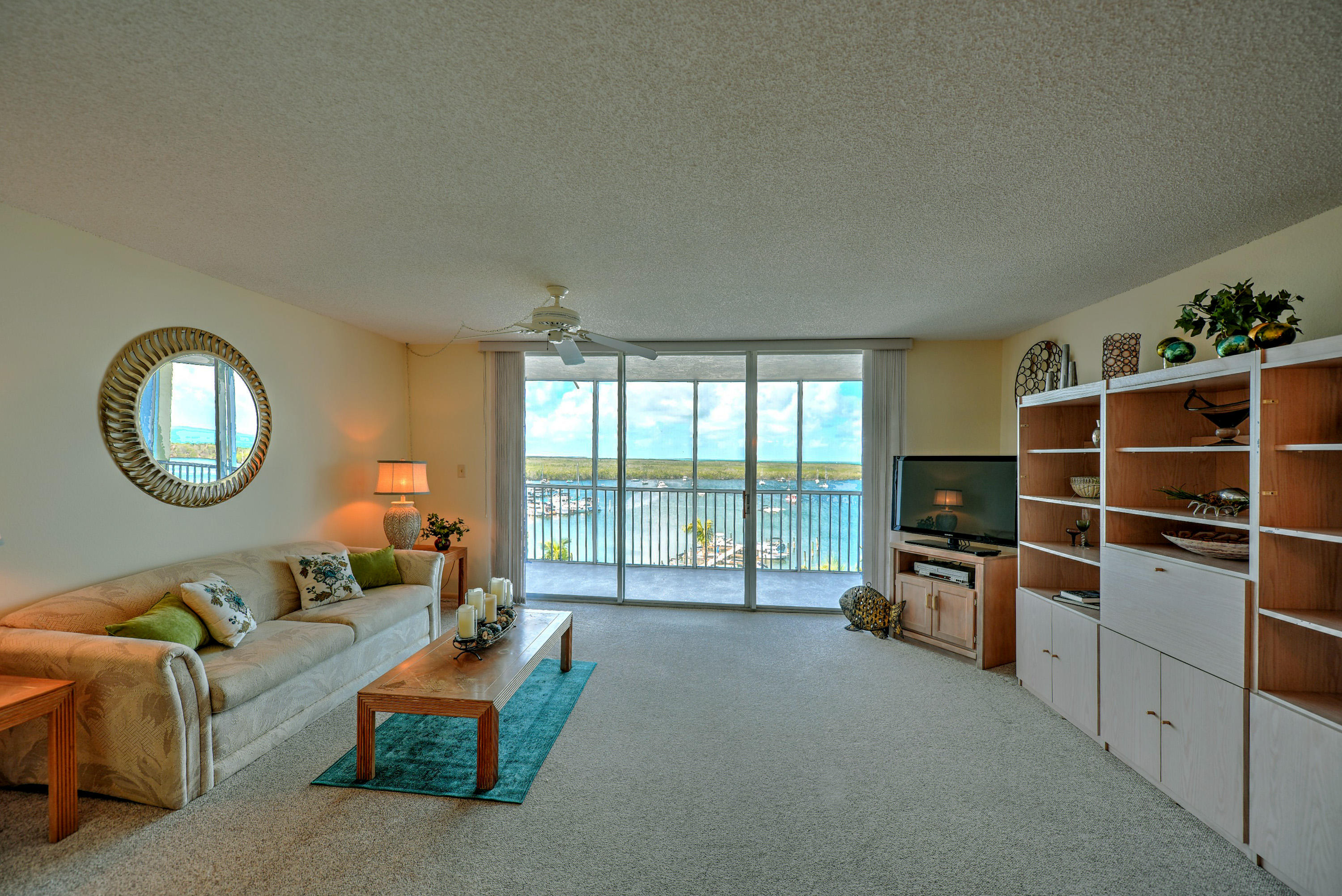 200 Harborview Drive, Unit PH 4 Tavernier, FL 33070 - Photo 12 of 33 a living room with furniture a flat screen tv and a large window
