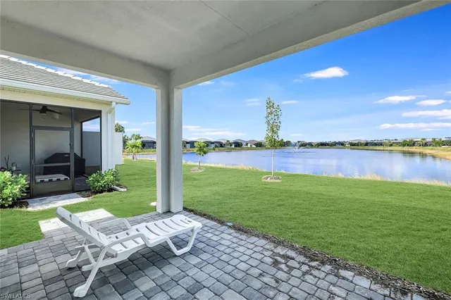 a view of a patio with lawn chairs floor to ceiling window and yard