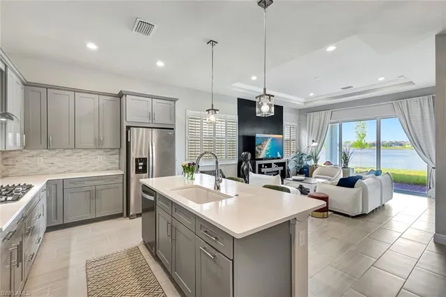 a kitchen with stainless steel appliances granite countertop a sink a stove and a refrigerator