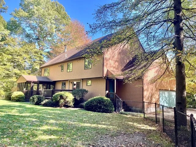 a front view of a house with a yard and trees