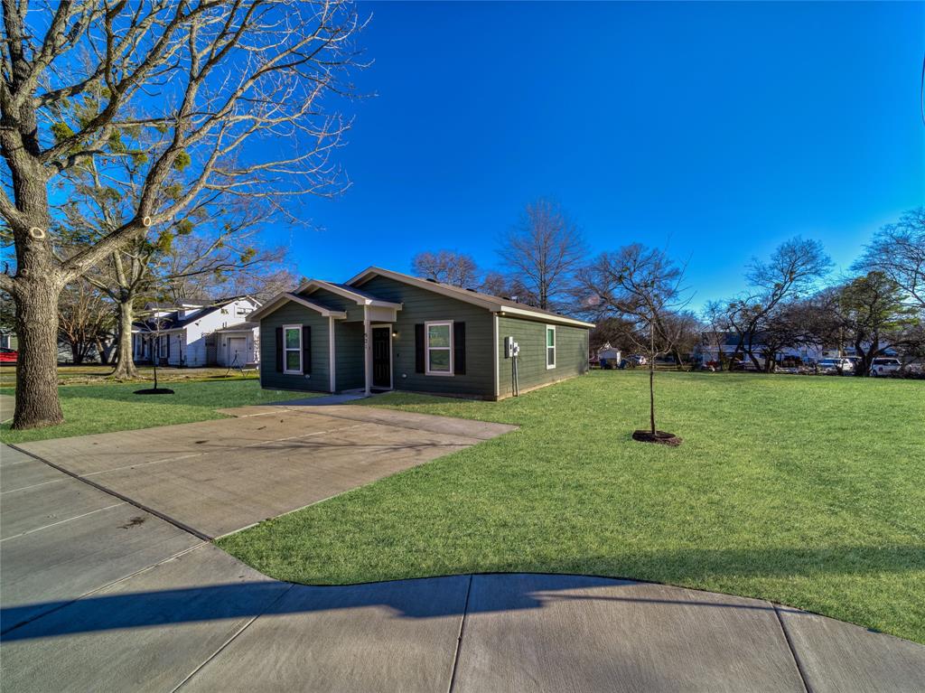 921 West 9th Street Bonham, TX 75418 - Photo 1 of 22 Single-story residence featuring dark green siding, white trim, and black window shutters