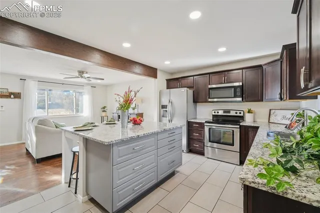 a kitchen with stainless steel appliances kitchen island granite countertop a sink and cabinets