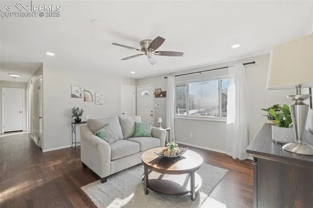 a living room with furniture and a wooden floor