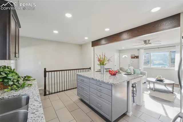 a kitchen with stainless steel appliances granite countertop a kitchen island hardwood floor sink stove and white cabinets
