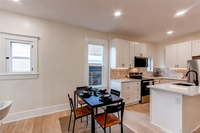 a kitchen with a stove a sink dishwasher and a refrigerator with wooden floor