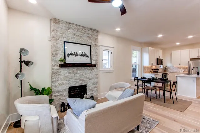 a living room with furniture kitchen view and a fireplace