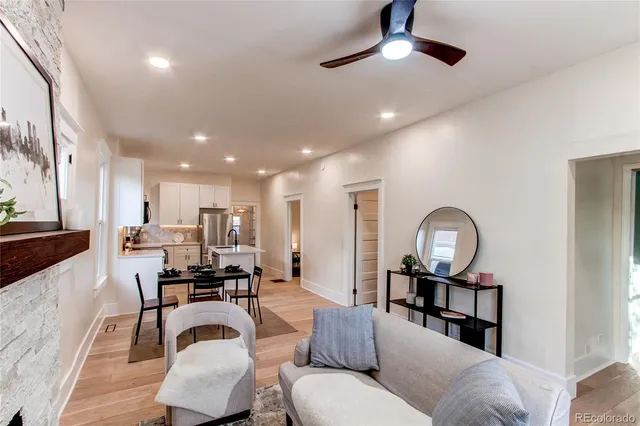a living room with furniture and a view of kitchen