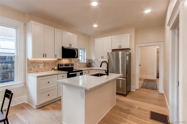 a kitchen with white cabinets and stainless steel appliances
