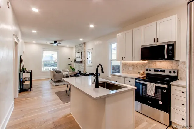 a kitchen with stainless steel appliances a stove a sink and a refrigerator