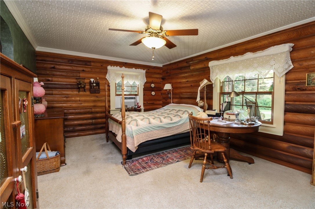 1070 Highland Ridge Road Lowell, OH 45744 - Photo 16 of 40 Carpeted bedroom featuring log walls, ceiling fan, and crown molding