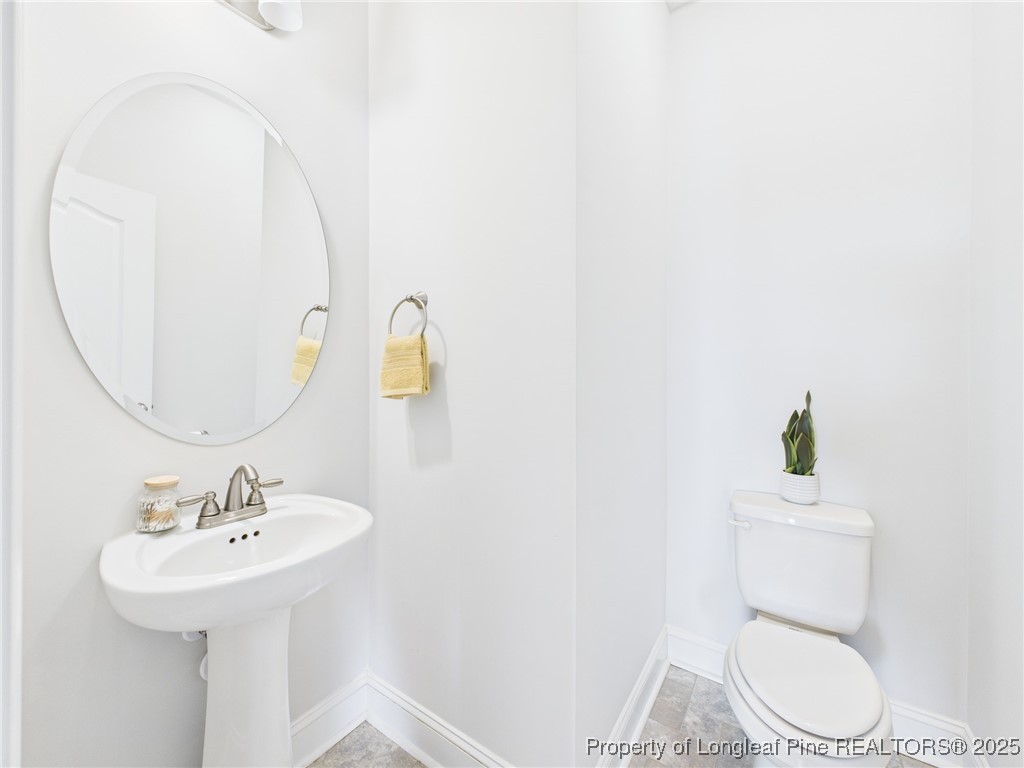 3149 Hunting Lodge Road Fayetteville, NC 28306 - Photo 11 of 49 a bathroom with a sink a toilet and a mirror