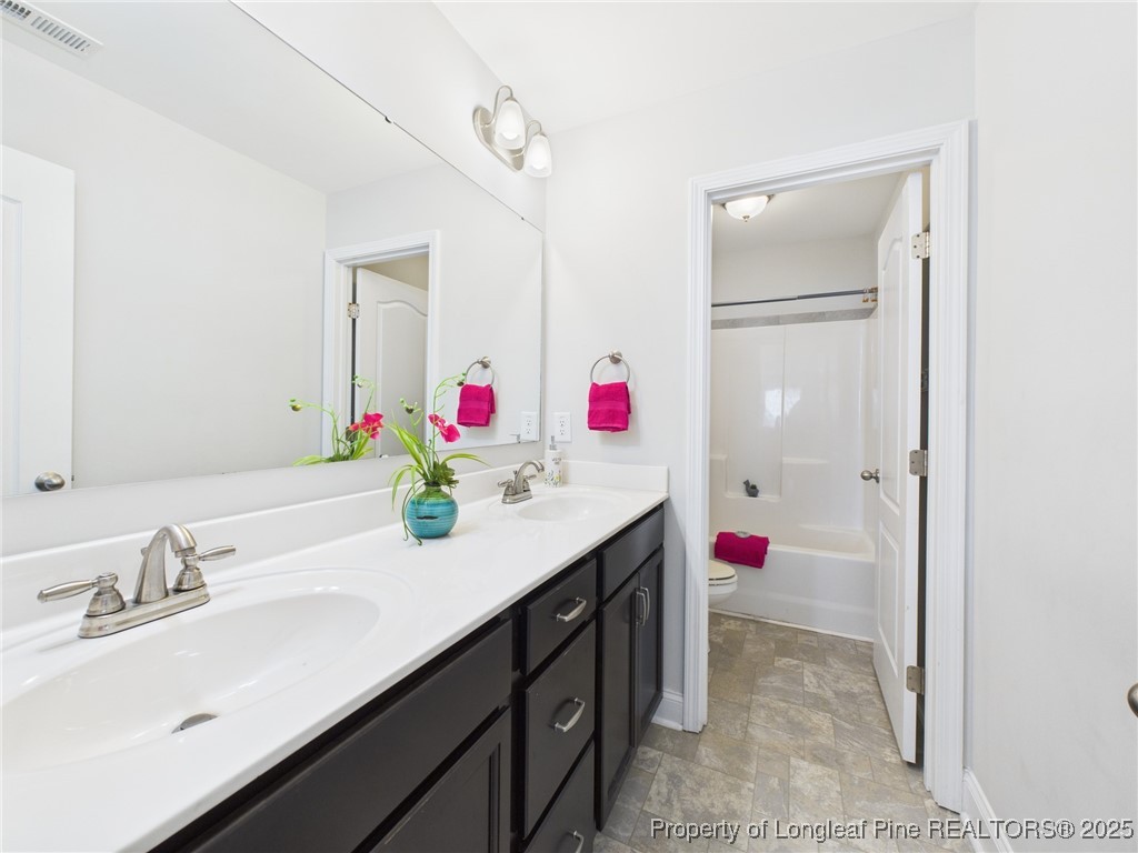 3149 Hunting Lodge Road Fayetteville, NC 28306 - Photo 38 of 49 a bathroom with a sink vanity and a mirror