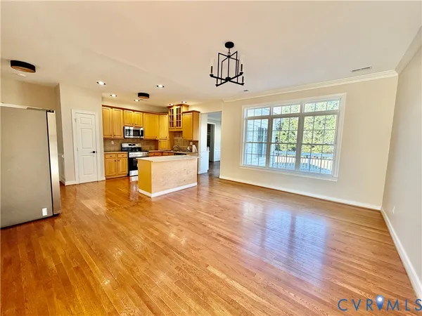 a view of a kitchen with wooden floor and electronic appliances