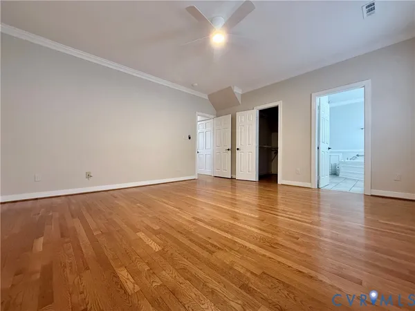 a view of an empty room with window and wooden floor