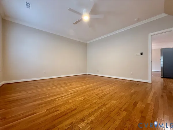 a view of empty room with wooden floor