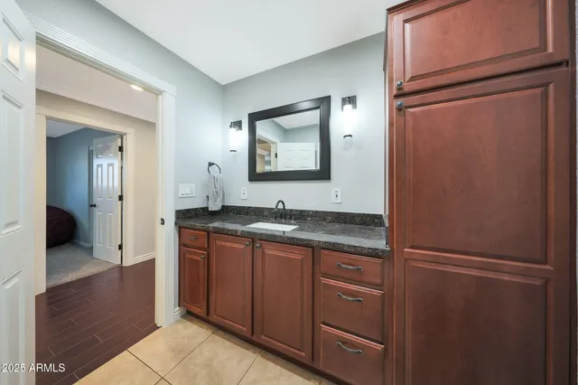 a bathroom with a granite countertop sink and a mirror