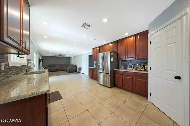 a kitchen with stainless steel appliances granite countertop a refrigerator and a sink