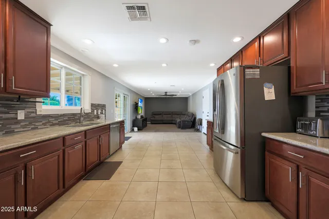 a kitchen with stainless steel appliances granite countertop a refrigerator and a sink