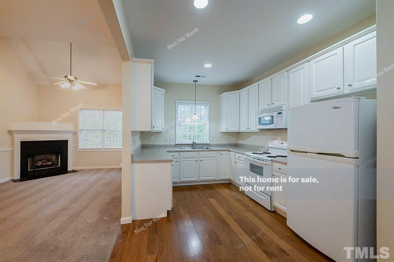 2608 Andover Glen Road Raleigh, NC 27604 - Photo 7 of 19 a kitchen with a refrigerator a stove top oven and a wooden floor