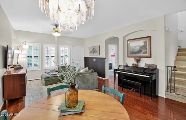 a living room with furniture a chandelier and a piano