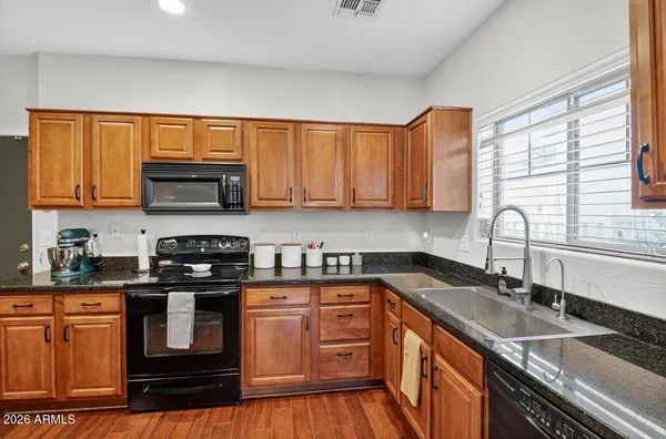 a kitchen with stainless steel appliances granite countertop a sink stove and microwave