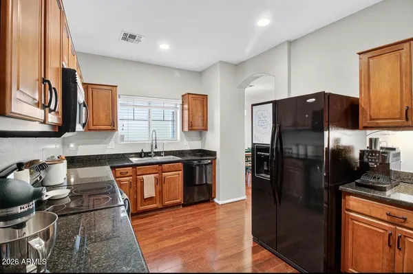 a kitchen with stainless steel appliances granite countertop a refrigerator stove and sink