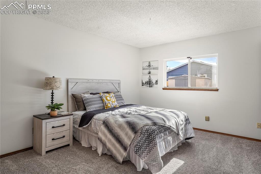 6385 Bismark Road Colorado Springs, CO 80922 - Photo 12 of 25 a bedroom with a bed and a cabinets