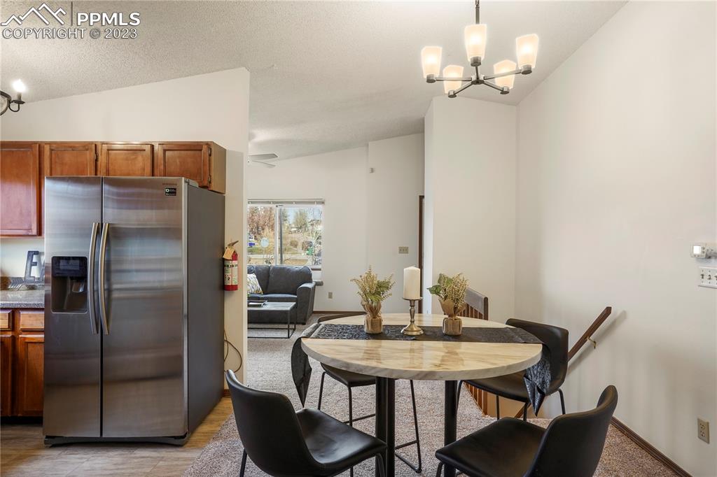6385 Bismark Road Colorado Springs, CO 80922 - Photo 4 of 25 a kitchen with stainless steel appliances a table and chairs