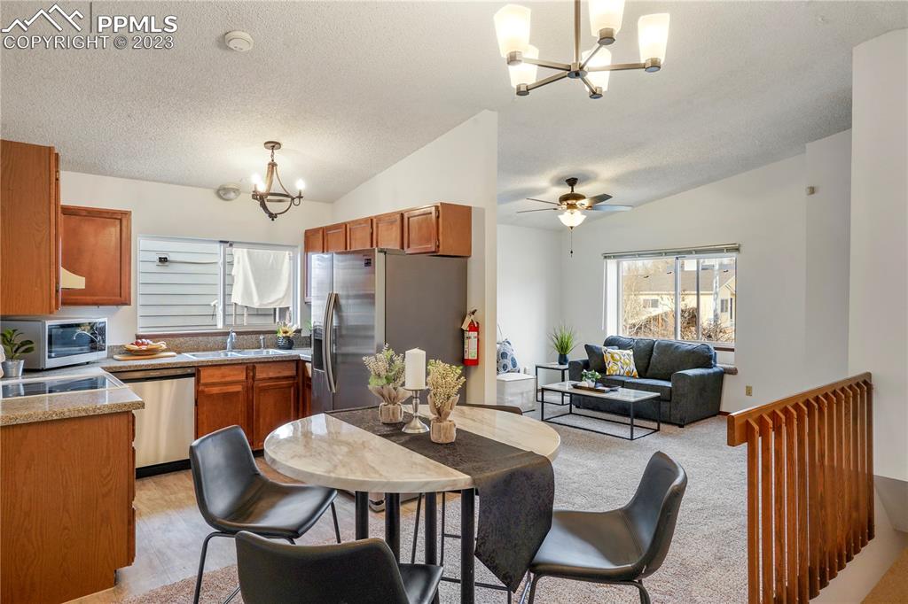 6385 Bismark Road Colorado Springs, CO 80922 - Photo 5 of 25 a kitchen with stainless steel appliances kitchen island granite countertop a dining table and chairs