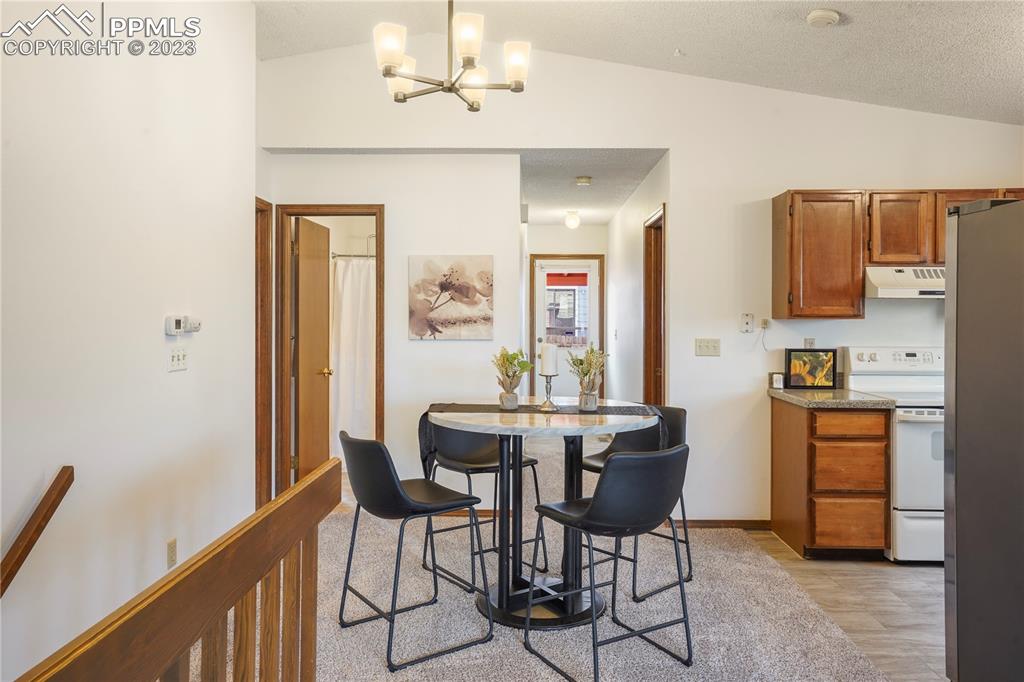 6385 Bismark Road Colorado Springs, CO 80922 - Photo 6 of 25 a view of a dining room with furniture and a chandelier
