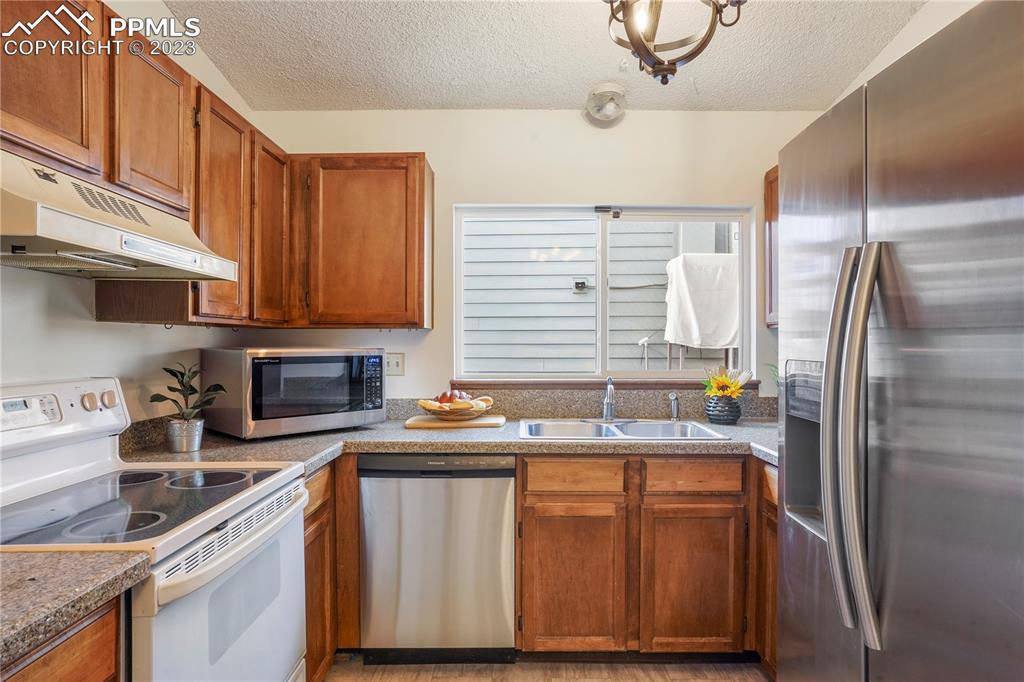 6385 Bismark Road Colorado Springs, CO 80922 - Photo 8 of 25 a kitchen with stainless steel appliances granite countertop a sink stove and refrigerator