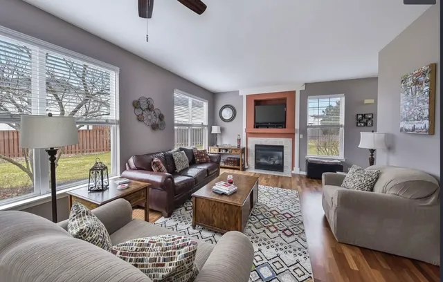 a living room with furniture a large window and a fireplace
