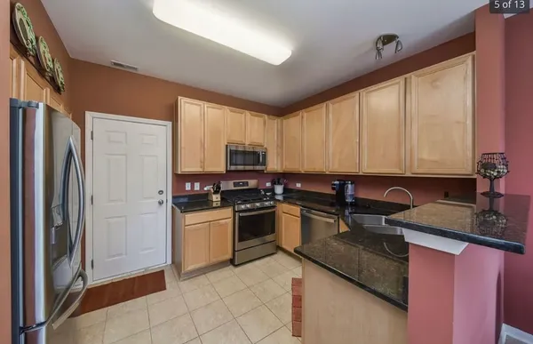 a kitchen with stainless steel appliances granite countertop a stove top oven a sink and dishwasher