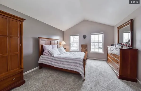 a spacious bedroom with a bed and wooden floor