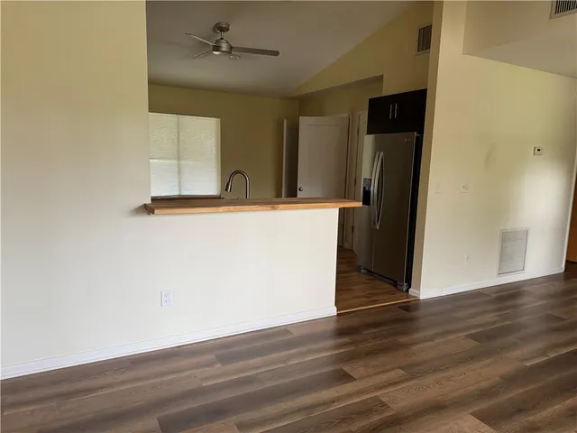 a view of a kitchen with wooden floor and a refrigerator