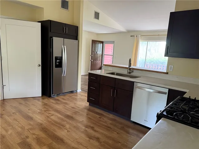 a kitchen with stainless steel appliances granite countertop a refrigerator and a sink