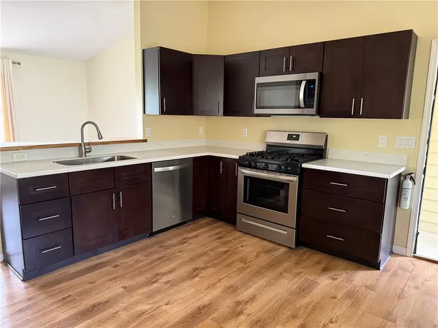 a kitchen with stainless steel appliances granite countertop a stove a sink and a microwave