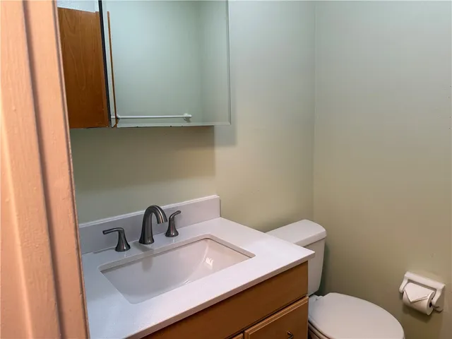 a bathroom with a sink a toilet and mirror