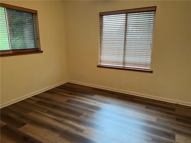 an empty room with wooden floor and a window