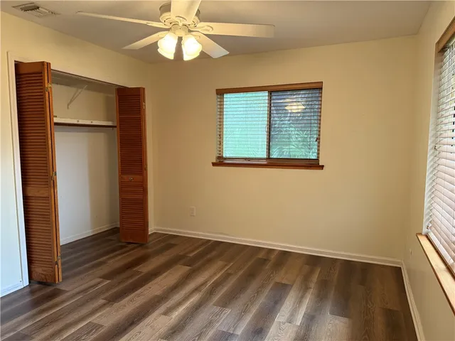 an empty room with a window and wooden floor
