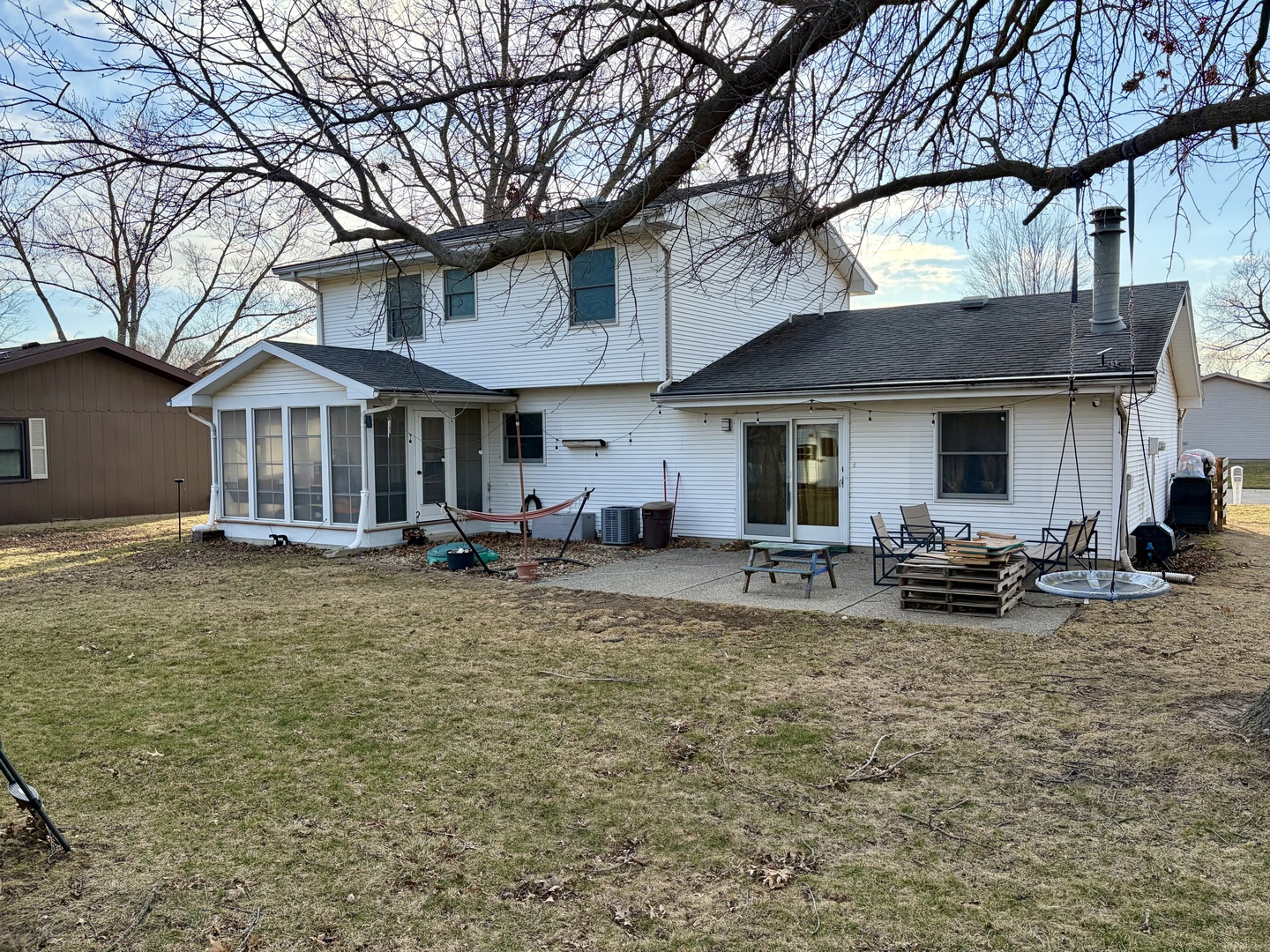 66 Holiday Drive Clinton, IL 61727 - Photo 40 of 43 a view of a house with a patio table and chairs under an umbrella