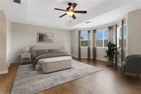 a spacious bedroom with a bed a couch and a chandelier