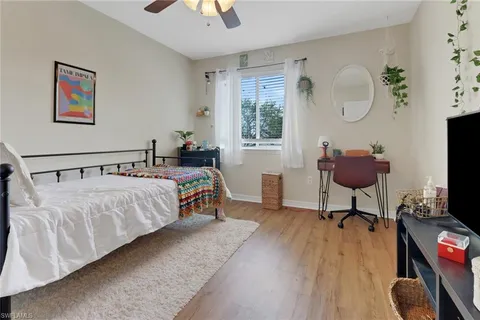 a bedroom with a bed a flat screen tv and a chandelier