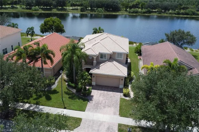an aerial view of a house with garden space and a lake view