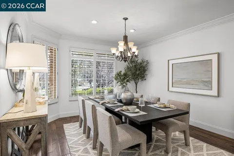 a living room with furniture a chandelier and a dining table